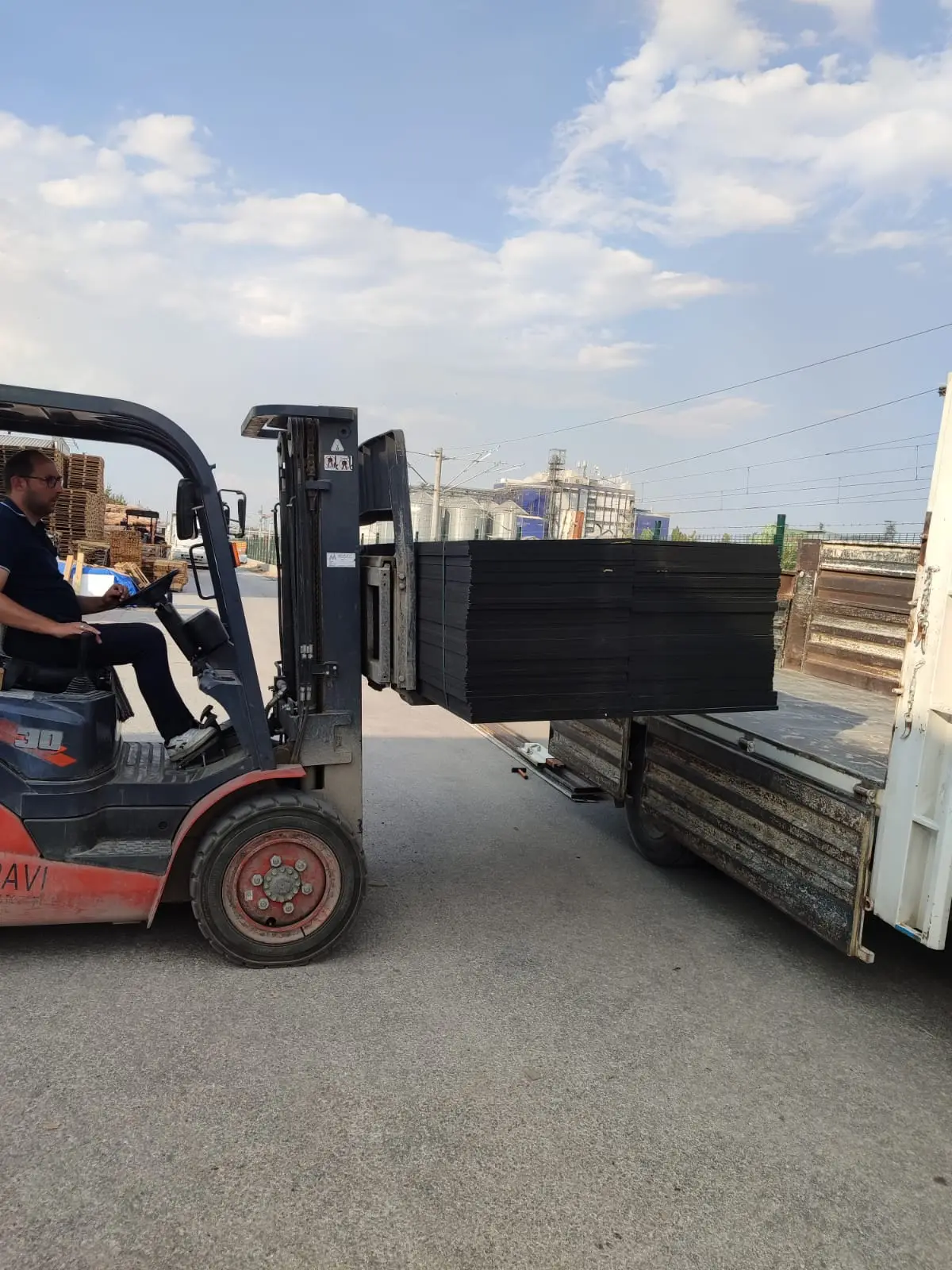 Forkliftle siyah kalıp plakası paketinin kamyonete yüklenmesi